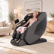 Woman relaxing in a charcoal PS5200 massage chair in a sunlit living room.